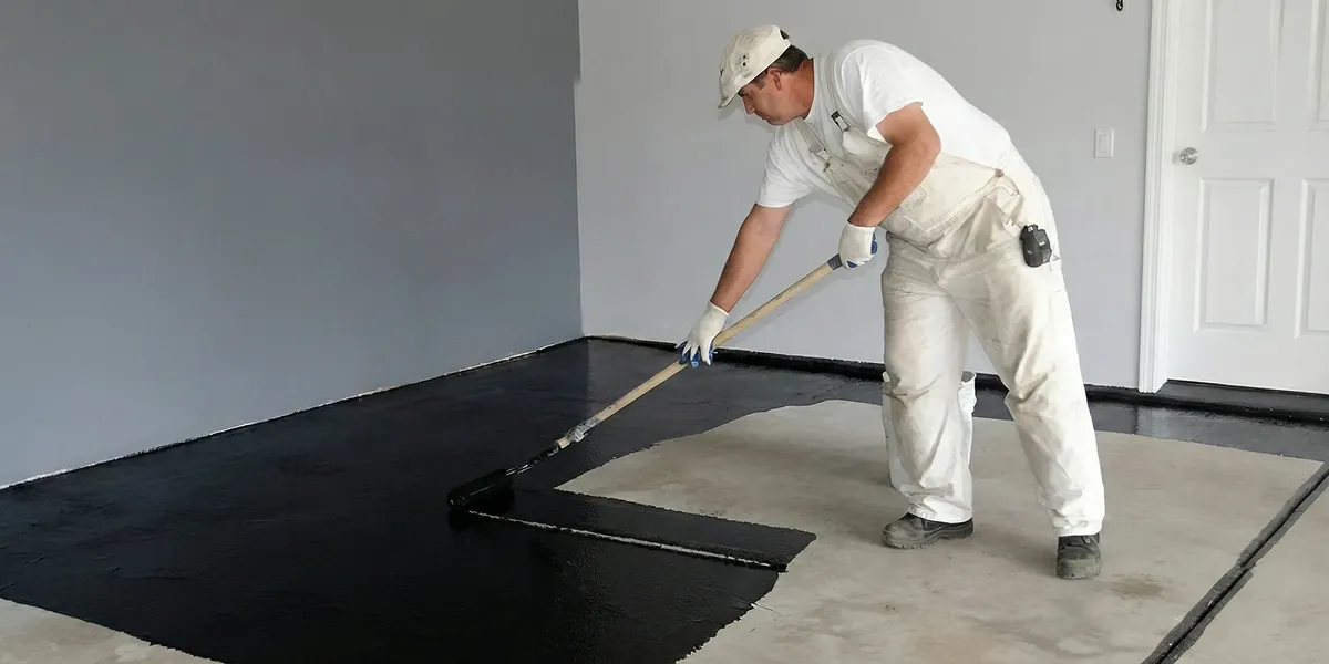 basement waterproofing professional applying waterproof coating to protect a basement floor in Erie, PA